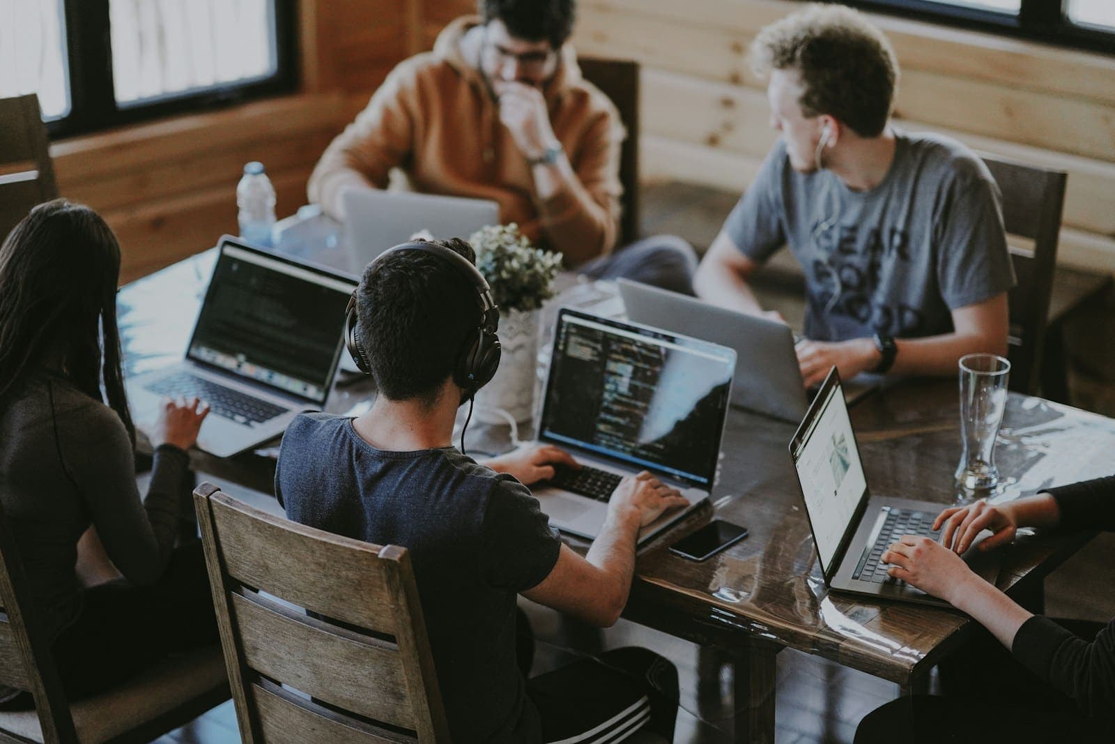 Equipe reunida em volta de laptops planejando um projeto